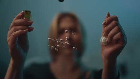 woman with addiction sits at table with scattered tablets