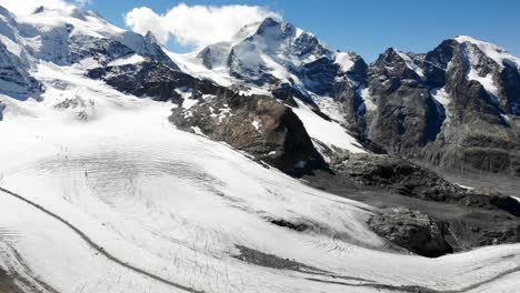 aerial flyover over fuorcla trovat peak at diavolezza in engadin, switzerland with a view of pers glacier and other peaks of the swiss alps around st