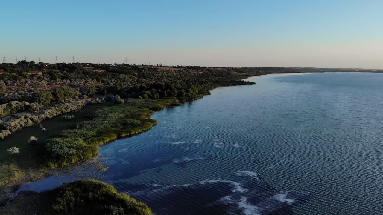 언덕에 울창한 초목이 있는 잔잔한 호수의 공중 전망