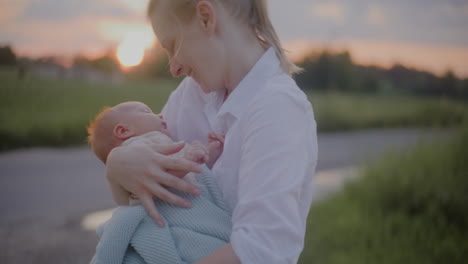 mother hugging baby at sunset clouds