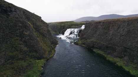 Aerial:-Flight-through-river-canyon-leading-to-Reykjafoss-cascading-waterfall-that-presents-itself-as-a-powerful-cascade-of-water