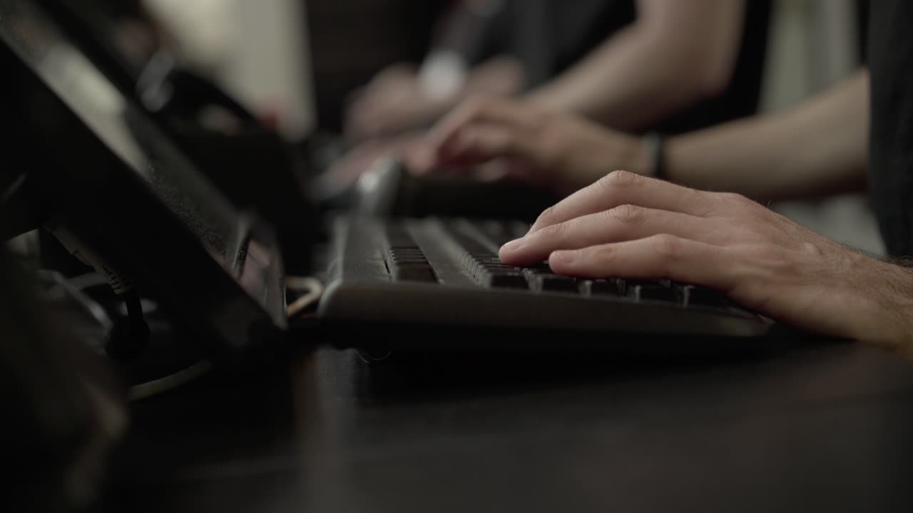 an typing on a computer keyboard side view, shallow DOF