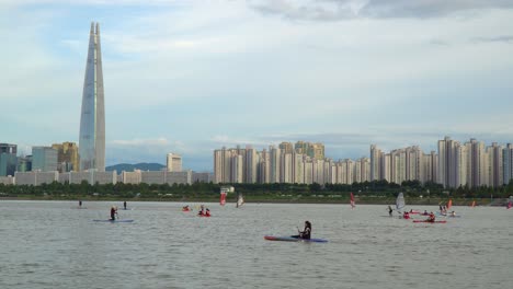 people kayaking, windsurfing, paddle boarding, and enjoying a picturesque day on the han river in seoul, south korea