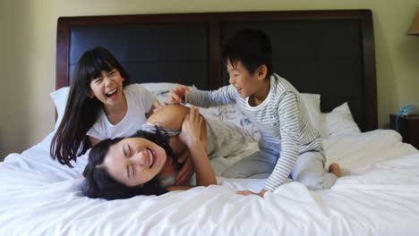 Mother-and-kids-having-fun-on-bed-in-bedroom-4k