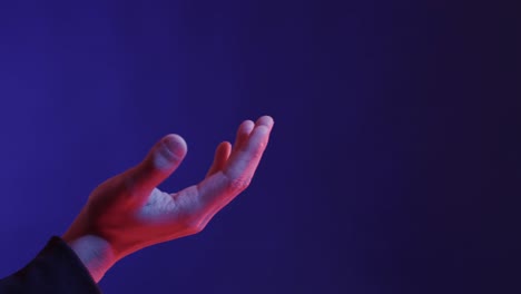 hand of asian man, touching virtual screen on blue background, copy space, slow motion