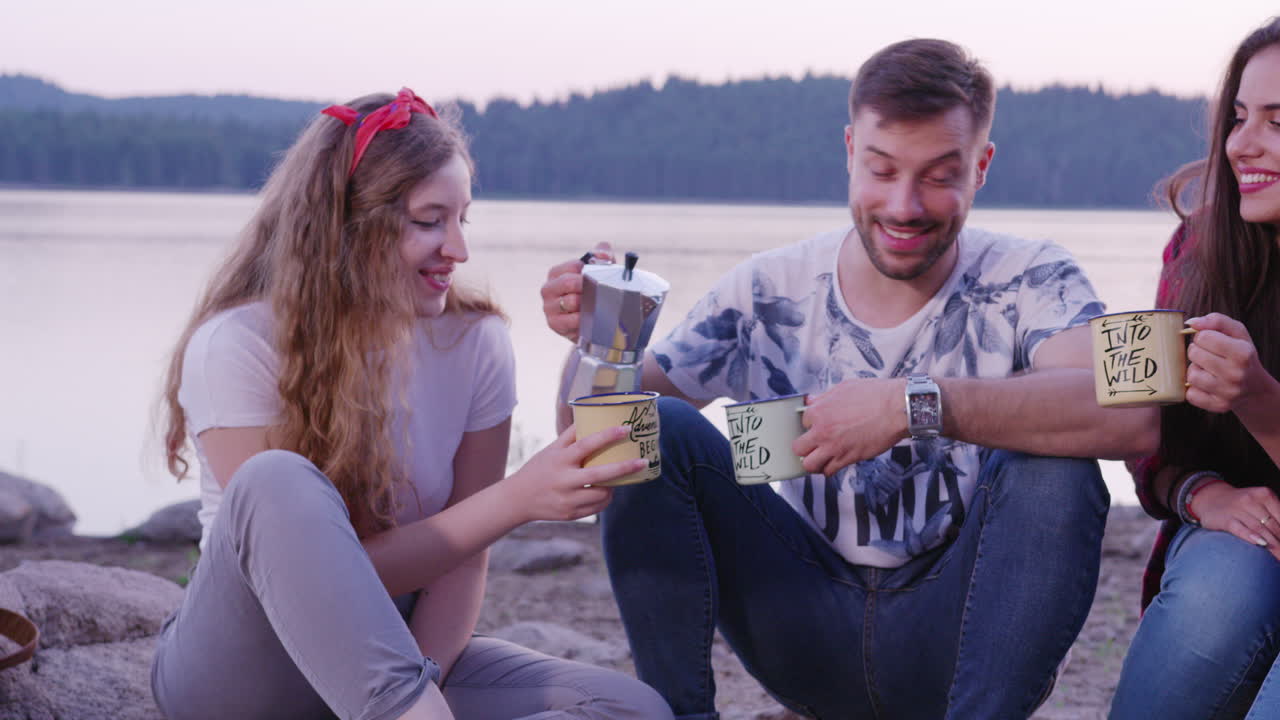 Amici che gustano il caffè in campeggio