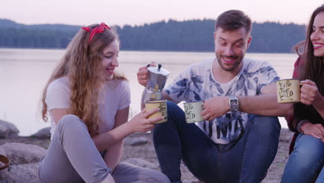 amigos disfrutando de café de campamento por el