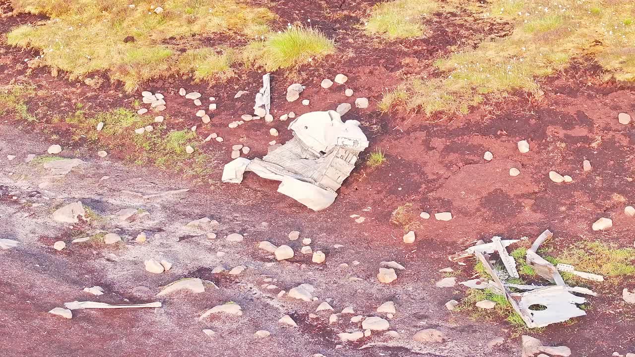 Drone view of scattered wreckage debris of the B-29 Superfortress WWII plane, on moorland terrain in the Peak District, England.