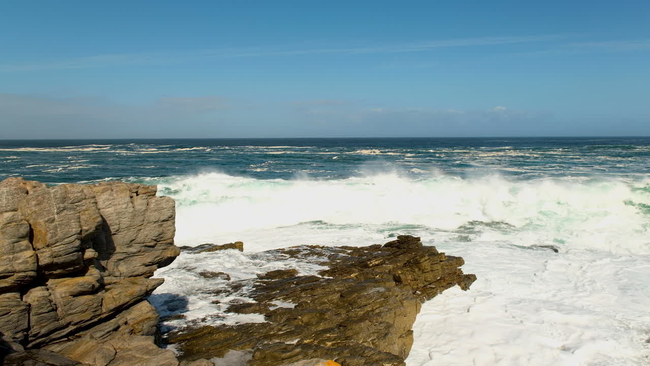 Onda che si infrange sulle rocce con un grande spruzzo bianco, aspra costa atlantica