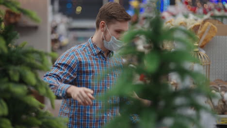 Vater-Und-Tochter-Wählen-Einen-Weihnachtsbaum-Für-Weihnachten.-Ein-Vater-Mit-Einer-Medizinischen-Maske-Im-Gesicht-Wählt-Mit-Seiner-Tochter-Am-Heiligabend-Schmuck-Und-Spielzeug-Aus-Und-Schmückt-Das-Haus-Und-Den-Weihnachtsbaum