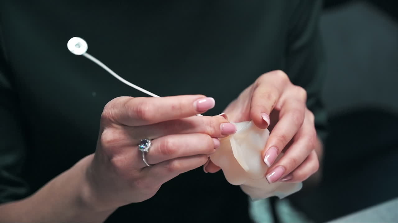 Una donna impegnata nella produzione di candele artigianali, mentre prepara uno stampo per la cera. Rallentatore