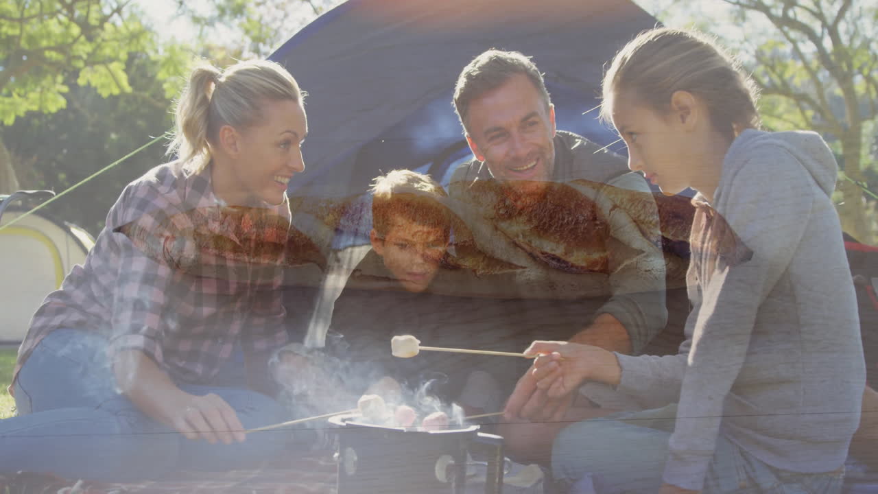Roasting marshmallows over campfire, family enjoying bread animation outdoors