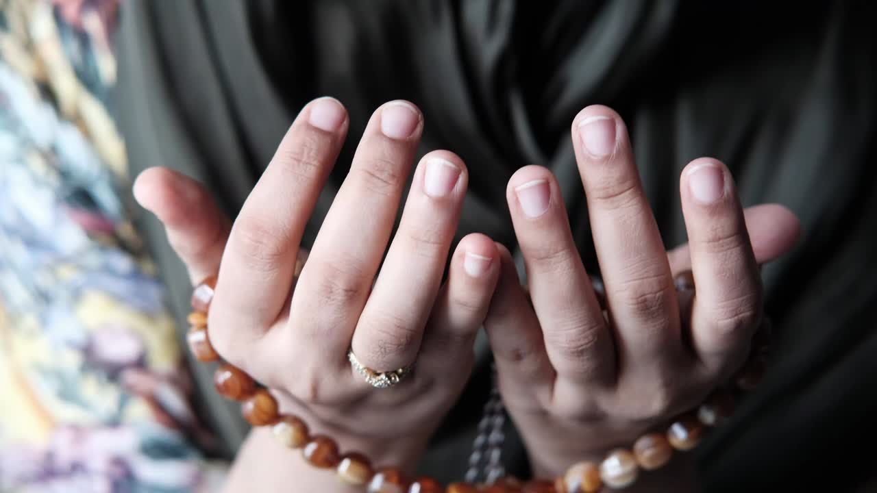 un primer plano de mujeres musulmanas rezando con las manos.