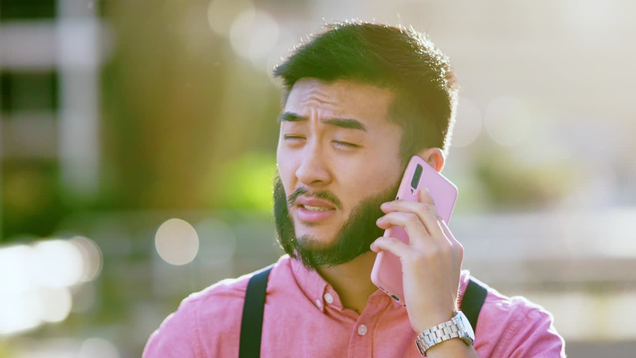 Asian man talking to the mobile in the street during sunset
