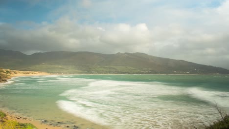 dark rain clouds flow over exotic coast and island, time lapse view