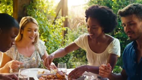 grupo de amigos multiculturales sonrientes al aire libre en casa comiendo juntos