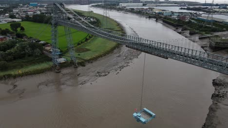 Rising-aerial-tilt-down-view-above-Newport-transporter-bridge-crossing-over-river-Usk-South-Wales-UK