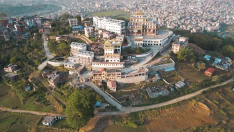 aerial view of a buddhist monastery complex on a hillside overlooking a city