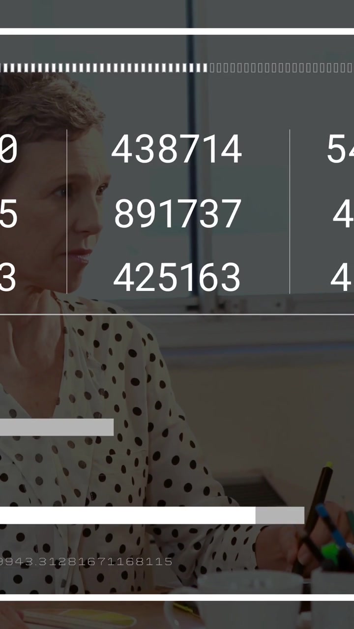 Vertical video: Watching woman in white polka-dot top tracking dashboard updates at office with pen