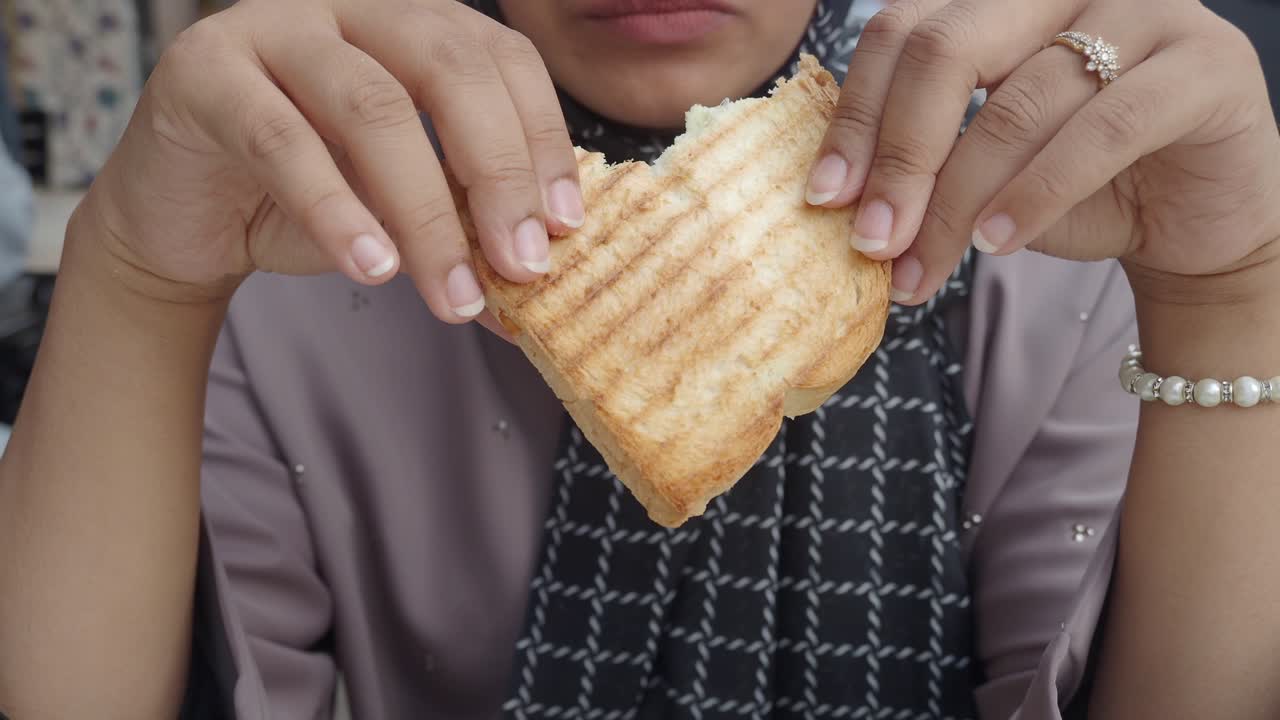 primer plano de una mujer comiendo tostadas a la parrilla