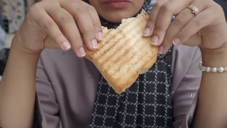 close-up of a woman eating grilled toast