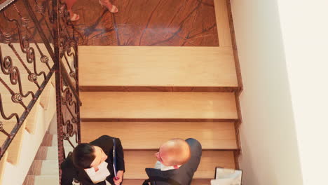 Top-view-of-businesspeople-stopping-on-stairs-and-talking