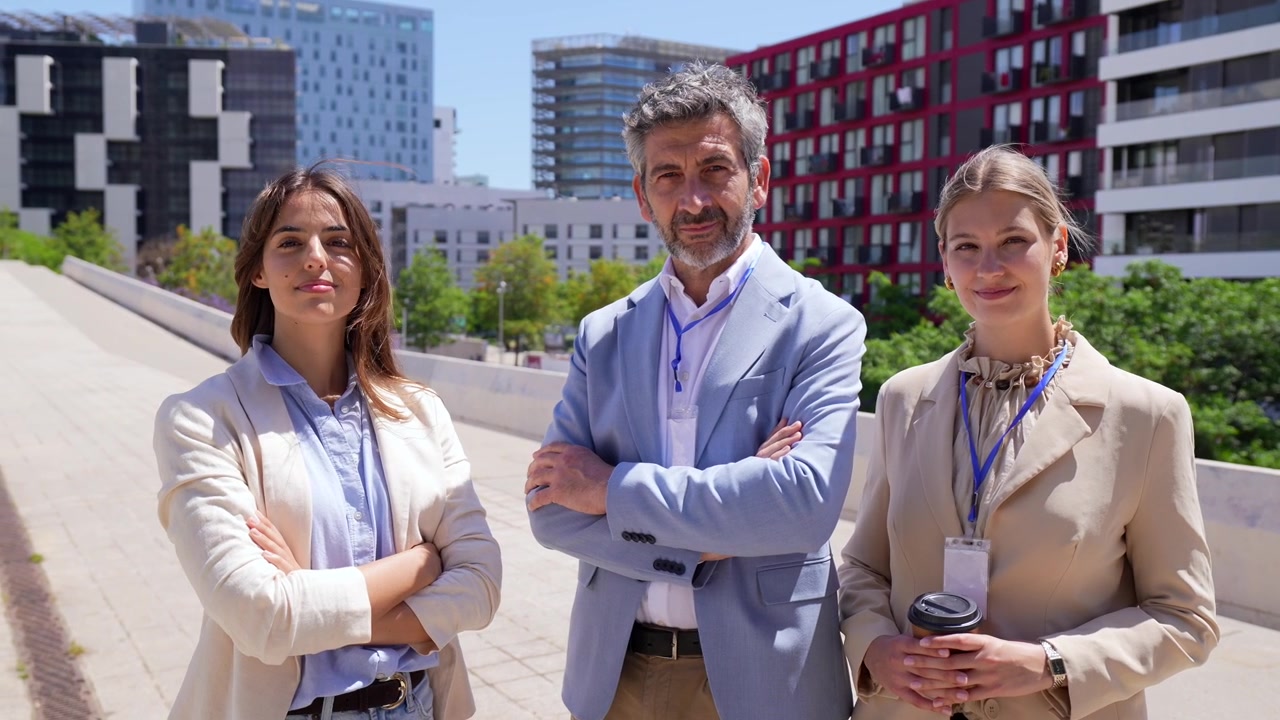 Zelfverzekerd zakelijk team dat buiten staat in een moderne stad