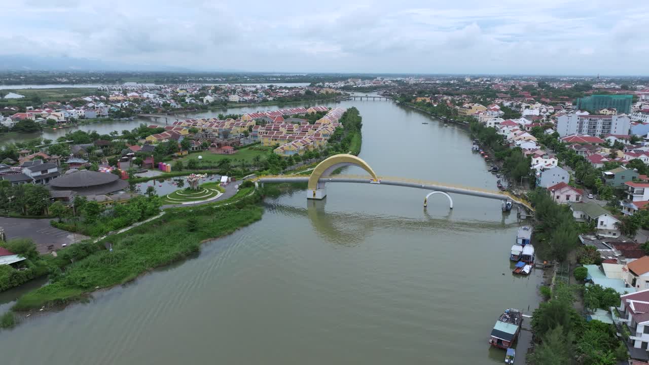 Peaceful river view with modern bridge and colorful homes in Hoi An, Vietnam