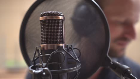 primer plano extremo del micrófono, el filtro pop y la boca y los labios de los cantantes