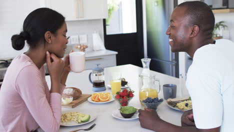 a diverse couple enjoys a breakfast together at home in the kitchen