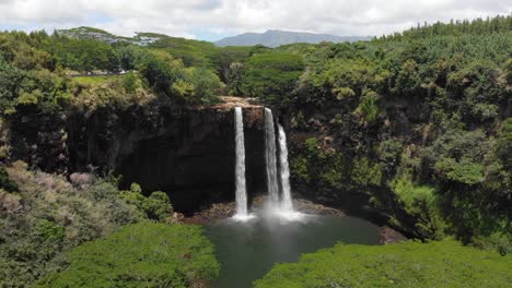 version four. aerial orbit of wailua falls and wailua state park, surrounded by forest jungle and trees.