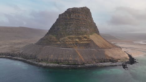 flying over patreksfjordur with calm blue waters and scenic mountain views in westfjords, iceland