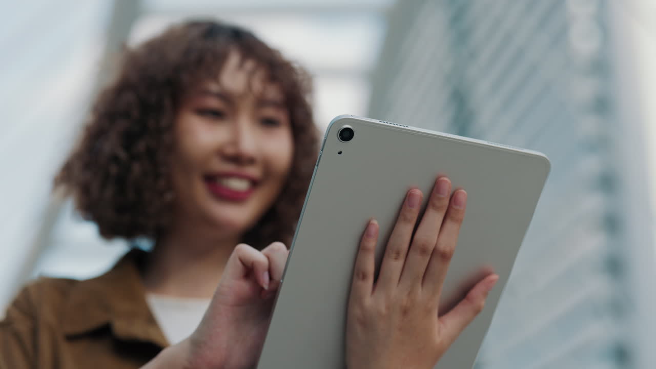 Woman using tablet outdoors in city