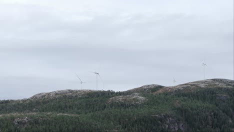 Molinos-De-Viento-En-La-Cima-De-Una-Montaña-Cerca-De-Hildremsvatnet,-Noruega---Disparo-De-Drones