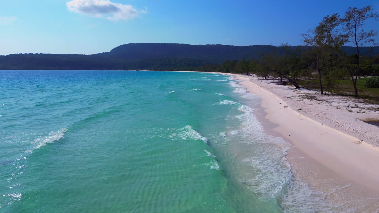 Tropical landscape showing turquoise sea washing white sand beach and green rainforest covering Koh Rong island in Cambodia. Breathtaking aerial view flight overflight flyover drone