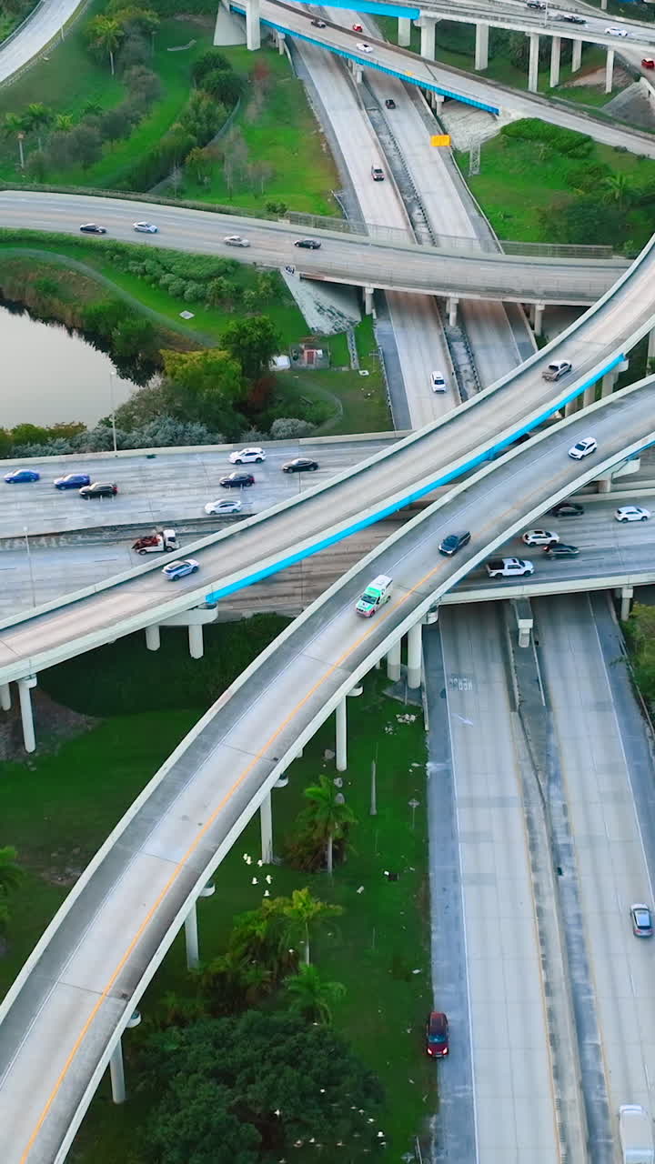Aerial view of evening multi-level junction of roads with bridges. Intersection of highways in Miami. Vertical video