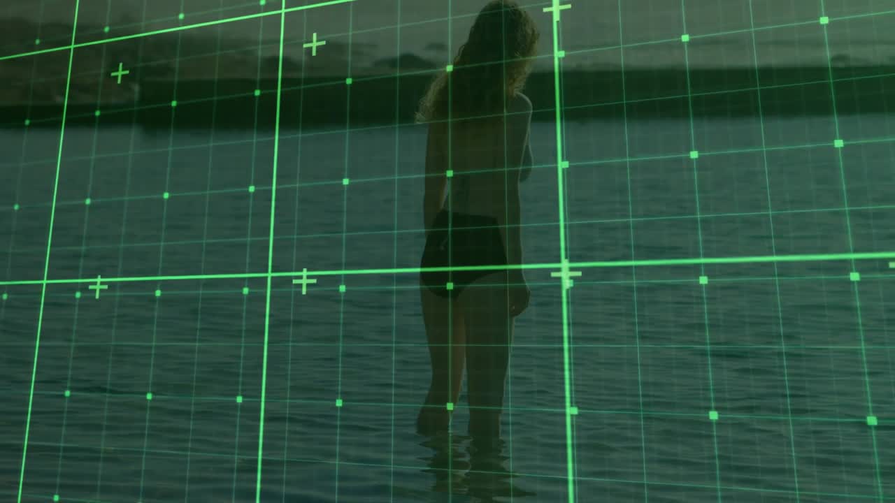 Woman wading along shoreline activating green grid overlay scanning body for technology analysis