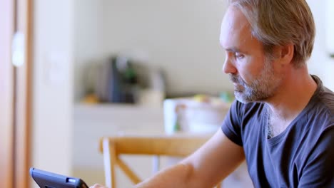 Man-using-digital-tablet-at-home-4k