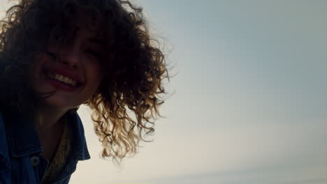 chica feliz posando en la cámara en la playa. retrato de una mujer sonriente cara