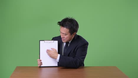 녹색 배경에 성숙한 일본 사업가