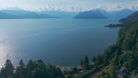 an aerial drone shot of a beautiful view of bowen island, anvil island and tantalus and serratus mountains under the blue sky