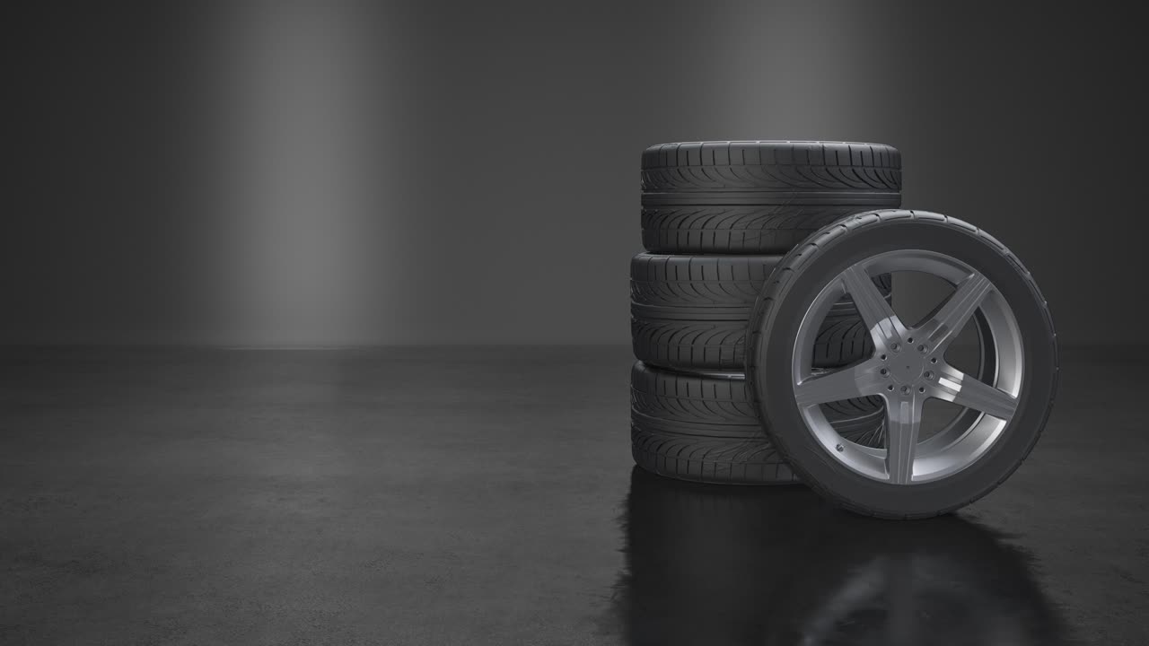 apilamiento de neumáticos y una rueda de prensa lateral sobre fondo gris