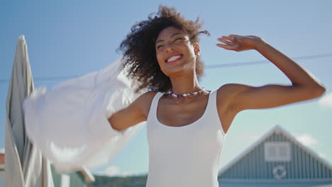 Chica-Sonriente-Quitándose-La-Camisa-Para-Ir-A-Nadar-En-El-Mar,-Primer-Plano-Orientado-Verticalmente.