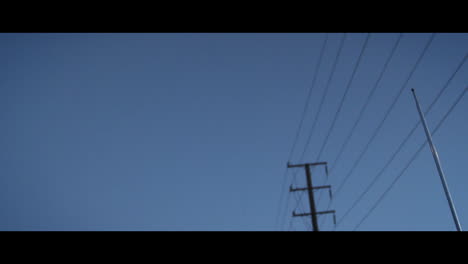 Power-lines-and-radio-aerial-seen-through-open-roof-of-car