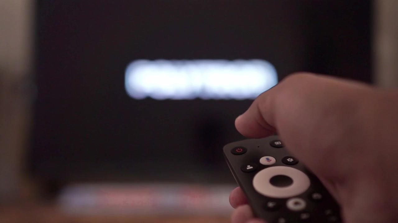Person pressing remote control button to switch on television. Home entertainment, streaming service, technology stock video clip.