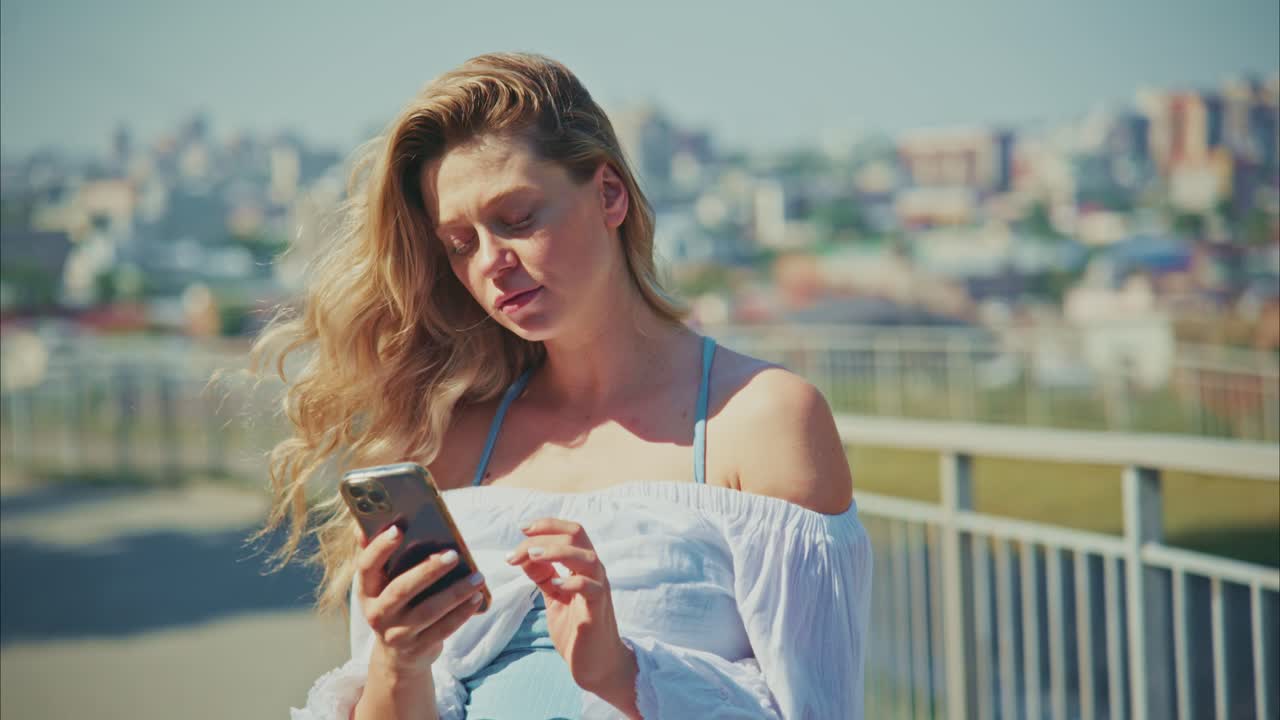 Giovane donna che usa lo smartphone all'aperto con lo sfondo della città