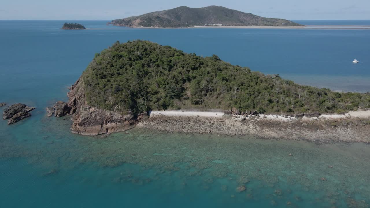 호주 퀸즐랜드의 오순절에 푸른 초목과 바위가 많은 해저가 있는 랭포드 섬