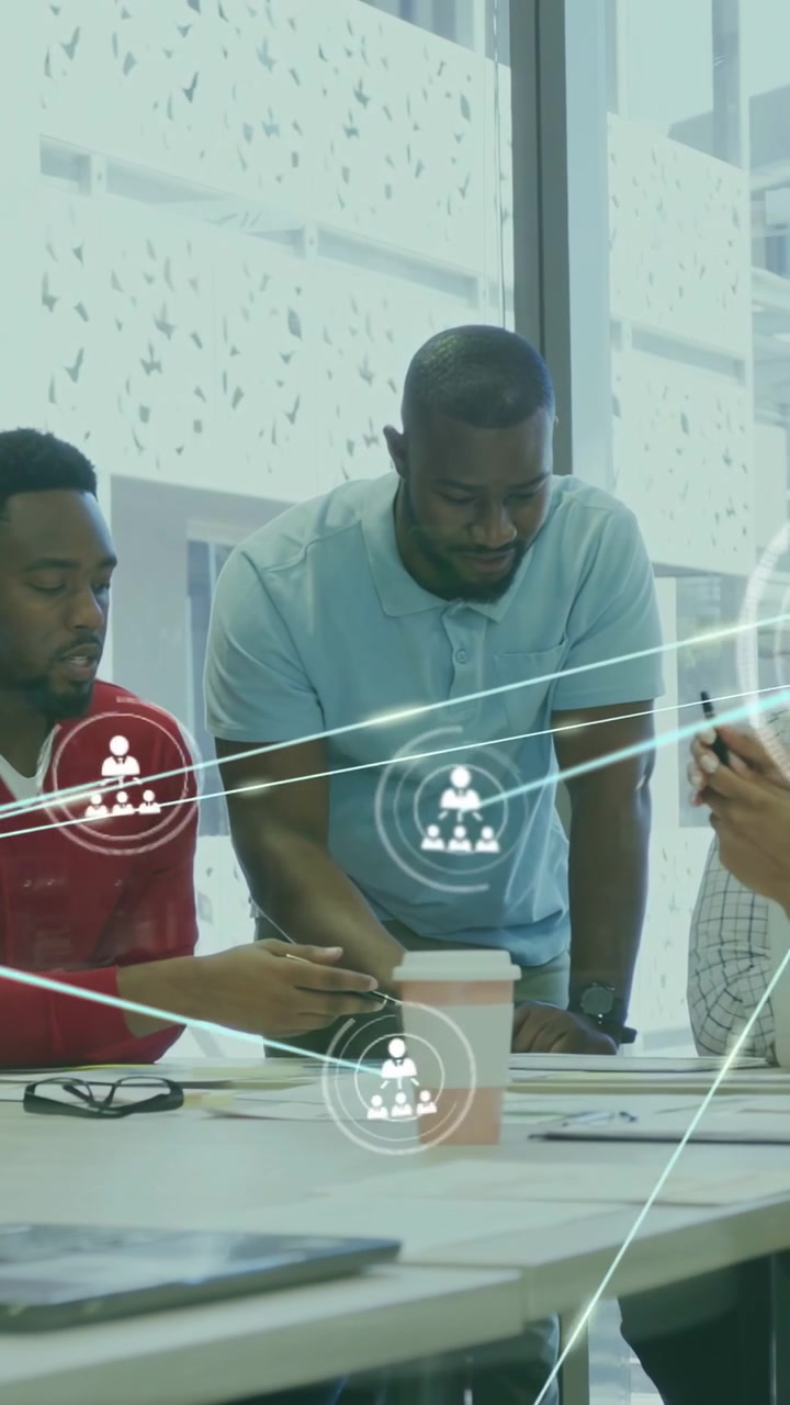 Vertical video: Standing man over table starting animated overlay while team mapping business links