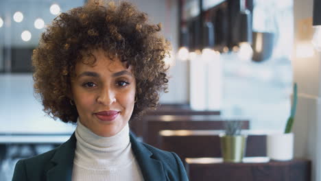 head and shoulders portrait of smiling african american businesswoman working in modern office