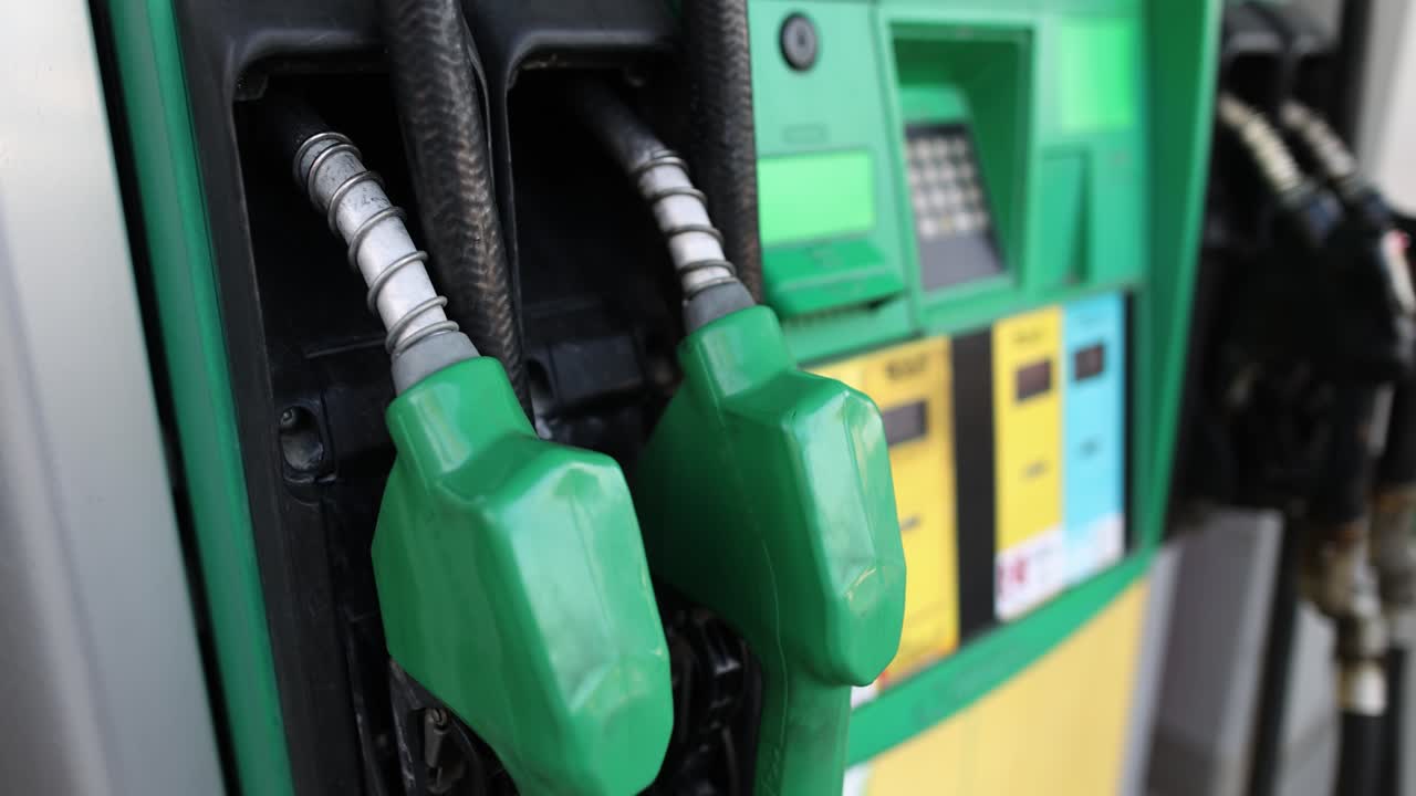 Close-up of green gas pump nozzles at a station